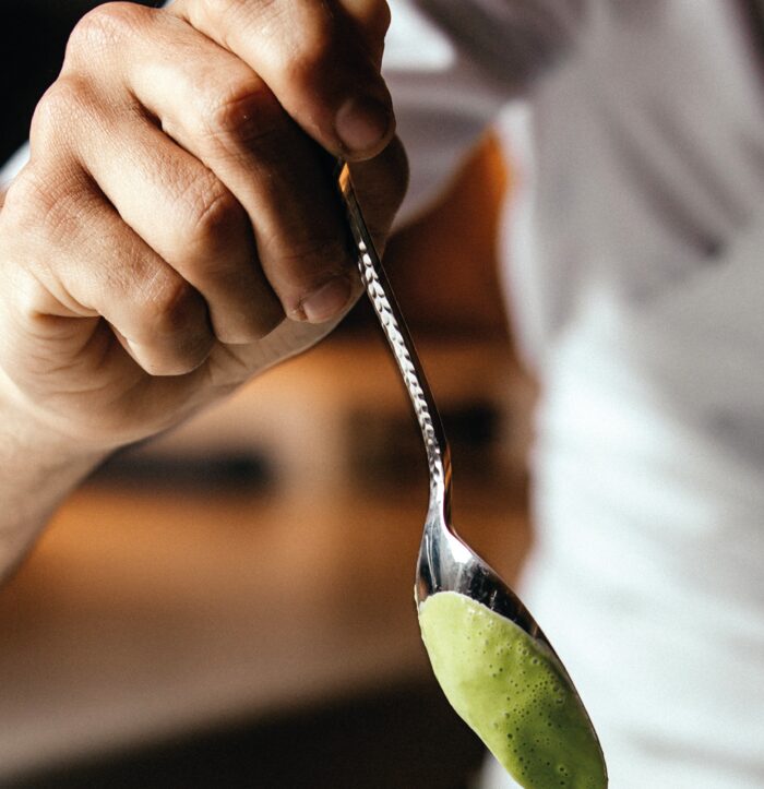 Chef a finalizar um prato com um creme verde